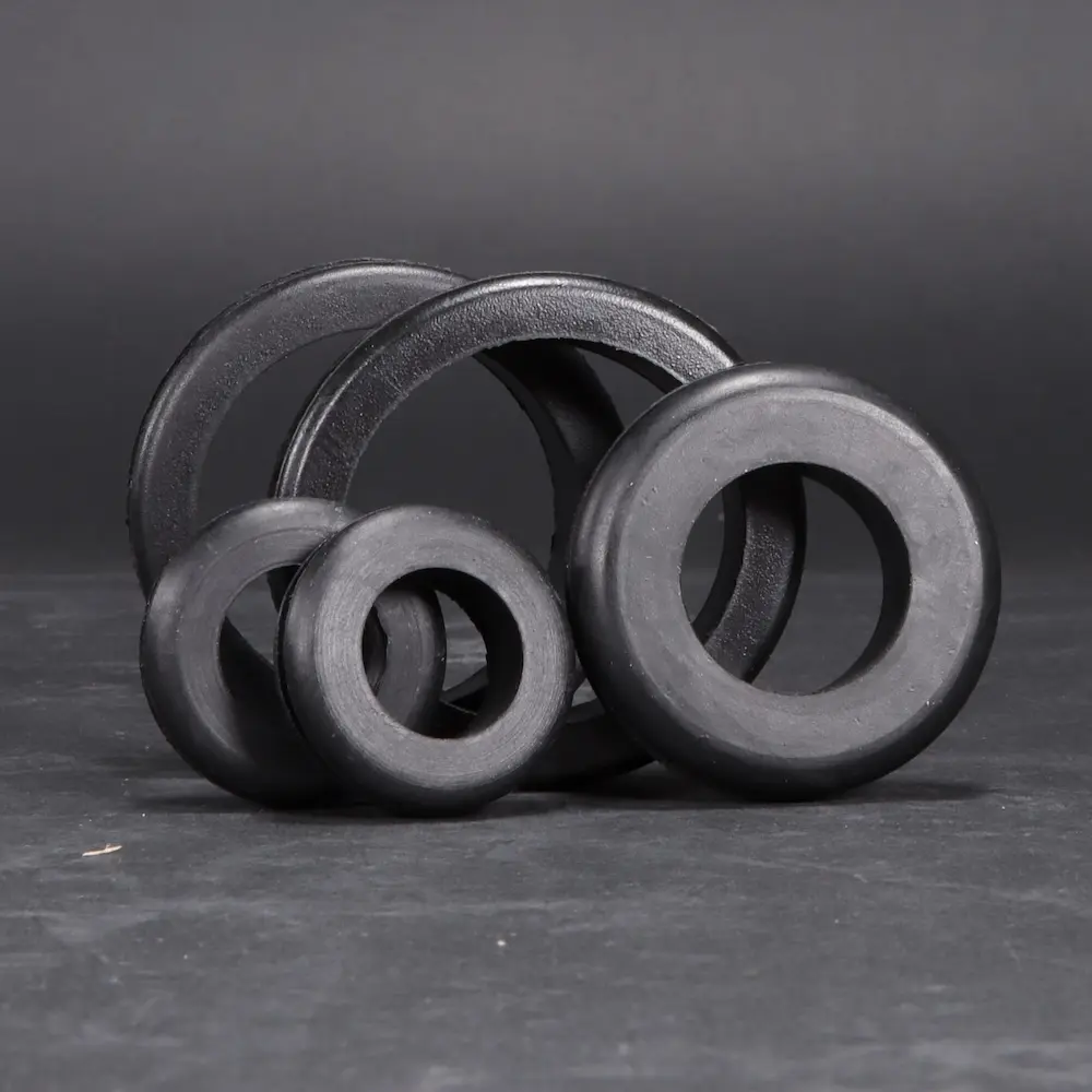 Multiple sizes of rubber grommets placed on a black background; Decorative Image